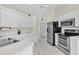 Bright kitchen with white cabinetry, tile floors, and stainless steel appliances at 2606 Trilby Ave, North Port, FL 34286