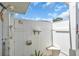 Enclosed outdoor shower area with white wood fence providing an area to rinse off before using the pool at 2606 Trilby Ave, North Port, FL 34286