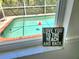 View from a window of a sparkling pool with an enclosed screen and brick trim, capturing a refreshing outdoor oasis at 2606 Trilby Ave, North Port, FL 34286