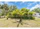 Landscaped backyard with mature palm trees and lush greenery, creating a private oasis at 2606 Trilby Ave, North Port, FL 34286