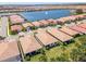An aerial view showcases homes by a lake with a fountain, offering serene waterfront living at 288 Soliera St, Nokomis, FL 34275