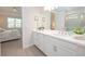 Bright bathroom with white cabinets, a double vanity, and tile floors at 288 Soliera St, Nokomis, FL 34275