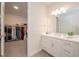 Bright bathroom featuring a quartz countertop, white cabinets, and view into closet at 288 Soliera St, Nokomis, FL 34275