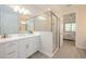 Bright bathroom featuring a glass shower, white cabinets, and a view into an adjacent bedroom at 288 Soliera St, Nokomis, FL 34275