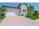 Attractive home exterior with a brick driveway, attached two-car garage, and tropical landscaping at 288 Soliera St, Nokomis, FL 34275