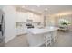 Well-lit kitchen with a center island, stainless steel appliances, white cabinets and tile flooring at 288 Soliera St, Nokomis, FL 34275
