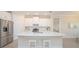 Bright kitchen with a center island, stainless steel appliances, white cabinets and tile flooring at 288 Soliera St, Nokomis, FL 34275