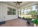 Screened-in patio with brick flooring, ceiling fan, and a view of the lush tropical landscaping at 288 Soliera St, Nokomis, FL 34275