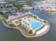 Aerial view of community pool with lounge chairs and palm trees overlooking the bay at 288 Soliera St, Nokomis, FL 34275