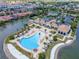 Aerial view of a community clubhouse and pool area with palm trees and lounge chairs by the water at 288 Soliera St, Nokomis, FL 34275
