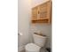 A cozy half-bathroom with a mounted cabinet above the toilet with neutral decor at 288 Soliera St, Nokomis, FL 34275