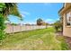 Beautiful backyard featuring a well-maintained lawn, white fence, and lush tropical landscaping at 335 Auburn Woods Cir, Venice, FL 34292