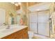 Bathroom with patterned walls, a sliding glass shower, and a white ceramic toilet at 335 Auburn Woods Cir, Venice, FL 34292