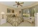 Neutral bedroom with large window and a wicker chair at 335 Auburn Woods Cir, Venice, FL 34292
