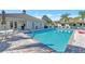 A community pool with crystal-clear water surrounded by a spacious patio and comfortable lounge chairs at 335 Auburn Woods Cir, Venice, FL 34292