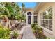 Inviting patio area with brick pavers, comfortable seating, and lush tropical landscaping creating a serene outdoor space at 335 Auburn Woods Cir, Venice, FL 34292