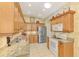Well-lit kitchen with granite countertops, stainless steel appliances, and ample cabinet space at 335 Auburn Woods Cir, Venice, FL 34292