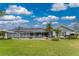 Lush backyard showcasing a well-manicured lawn, palm trees, and a screened pool, enhancing outdoor living at 351 Eden Dr, Englewood, FL 34223