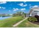 Scenic backyard with a pond view, complemented by lush greenery and a screened-in lanai, perfect for relaxation at 351 Eden Dr, Englewood, FL 34223