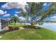 Picturesque backyard featuring lush landscaping, mature trees, and a serene view of the lake at 351 Eden Dr, Englewood, FL 34223