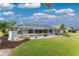 Expansive backyard featuring a well-maintained lawn, tropical plants, and a screened pool area at 351 Eden Dr, Englewood, FL 34223