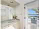 Bathroom with a large mirror, outdoor access to the pool, and natural light at 351 Eden Dr, Englewood, FL 34223