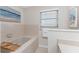 Bathroom featuring soaking tub, window, towel rack, and artwork at 351 Eden Dr, Englewood, FL 34223
