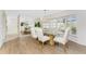 Dining room with large windows, wood-look floors and mirrored accent wall at 351 Eden Dr, Englewood, FL 34223