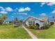 Charming blue home featuring a tile roof, lush landscaping, and a screened-in lanai overlooking the yard at 351 Eden Dr, Englewood, FL 34223