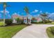 Beautiful home featuring tropical landscaping, a paver driveway, and a charming covered entrance at 351 Eden Dr, Englewood, FL 34223