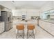 Well-equipped kitchen with island, bar seating and stainless steel refrigerator at 351 Eden Dr, Englewood, FL 34223