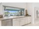 Kitchen sink featuring a window overlooking a screened lanai, pool, and beautiful lake views at 351 Eden Dr, Englewood, FL 34223