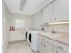 Laundry room with white cabinets and light pink countertops at 351 Eden Dr, Englewood, FL 34223