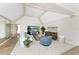 Bright and airy living room with vaulted ceilings, neutral walls, carpet floors, and access to a patio at 351 Eden Dr, Englewood, FL 34223