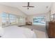 Bright main bedroom with large windows, ceiling fan, and walk-out access to a screened-in pool and patio area at 351 Eden Dr, Englewood, FL 34223