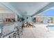 Outdoor patio featuring ceiling fan, tile floors, bar seating, comfortable couches, and an outdoor kitchen at 351 Eden Dr, Englewood, FL 34223