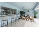Outdoor patio featuring ceiling fan, tile floors, bar seating, comfortable couches, and an outdoor kitchen at 351 Eden Dr, Englewood, FL 34223