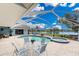 Inviting screened pool and spa with seating, set against the backdrop of a tranquil lake view at 351 Eden Dr, Englewood, FL 34223
