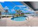 Beautiful screened pool with a relaxing spa, surrounded by a brick patio and lush landscaping at 351 Eden Dr, Englewood, FL 34223