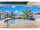 Inviting screened pool area with a spa, showcasing tranquil lake views and a spacious patio at 351 Eden Dr, Englewood, FL 34223