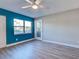 Bright, minimalist bedroom with light wood floors, a ceiling fan, and a window letting in ample natural light at 429 Cerromar Ln # 352, Venice, FL 34293