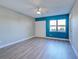 Bright bedroom featuring light wood floors, a ceiling fan, and a blue accent wall with a large window at 429 Cerromar Ln # 352, Venice, FL 34293
