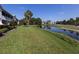 Manicured lawn leading to a tranquil pond surrounded by lush landscaping at 432 Sunset Lake Blvd # 205, Venice, FL 34292