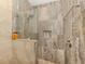 Elegant shower with stone tile, seamless glass door, and built-in niche for storage at 432 Sunset Lake Blvd # 205, Venice, FL 34292