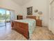 Cozy bedroom with access to lanai, complemented by a decorative quilt and accents at 432 Sunset Lake Blvd # 205, Venice, FL 34292