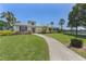 Welcoming community clubhouse with lush landscaping, inviting path and lake view at 432 Sunset Lake Blvd # 205, Venice, FL 34292