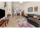 Inviting living room with tile flooring, leather sectional, and view into dining area at 432 Sunset Lake Blvd # 205, Venice, FL 34292