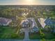 Stunning aerial view of home featuring lush landscaping, pool, and golf course views in Boca Royale Golf and Country Club at 48 Grande Fairway, Englewood, FL 34223