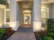 Inviting front entrance with brick steps and mature landscaping, illuminated by warm lighting at 48 Grande Fairway, Englewood, FL 34223