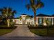 Charming home with a brick driveway, mature palm trees, and a well-lit facade at 48 Grande Fairway, Englewood, FL 34223